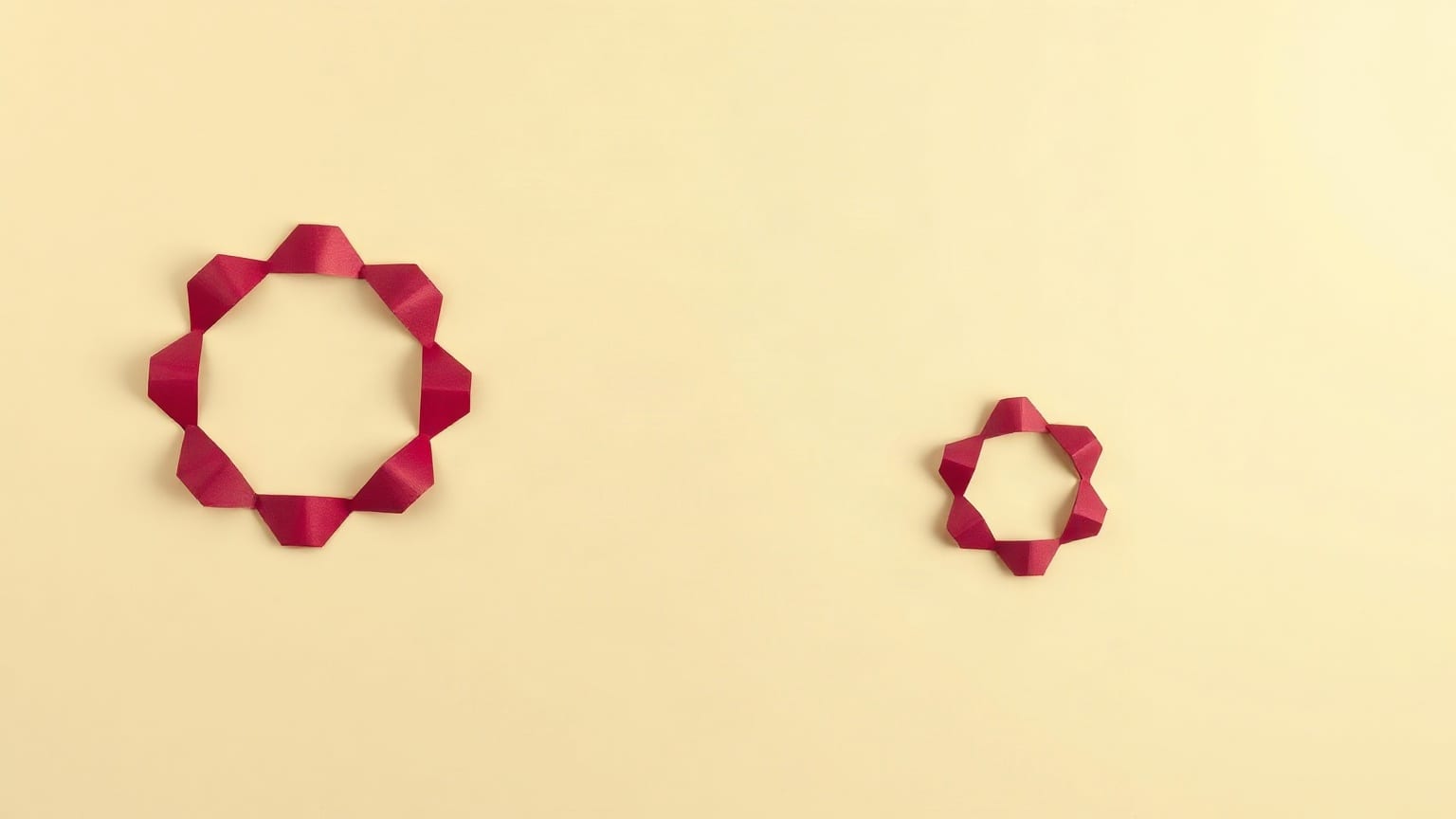Un decágono de papel naranja sobre fondo oscuro, con un hexágono más pequeño de papel claro en la esquina opuesta